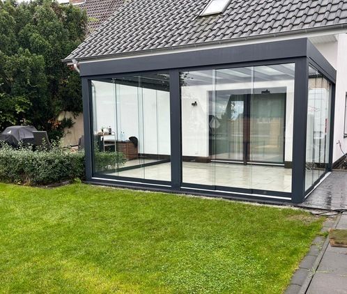 Freistehende Glasoase im Garten mit umlaufender Verglasung